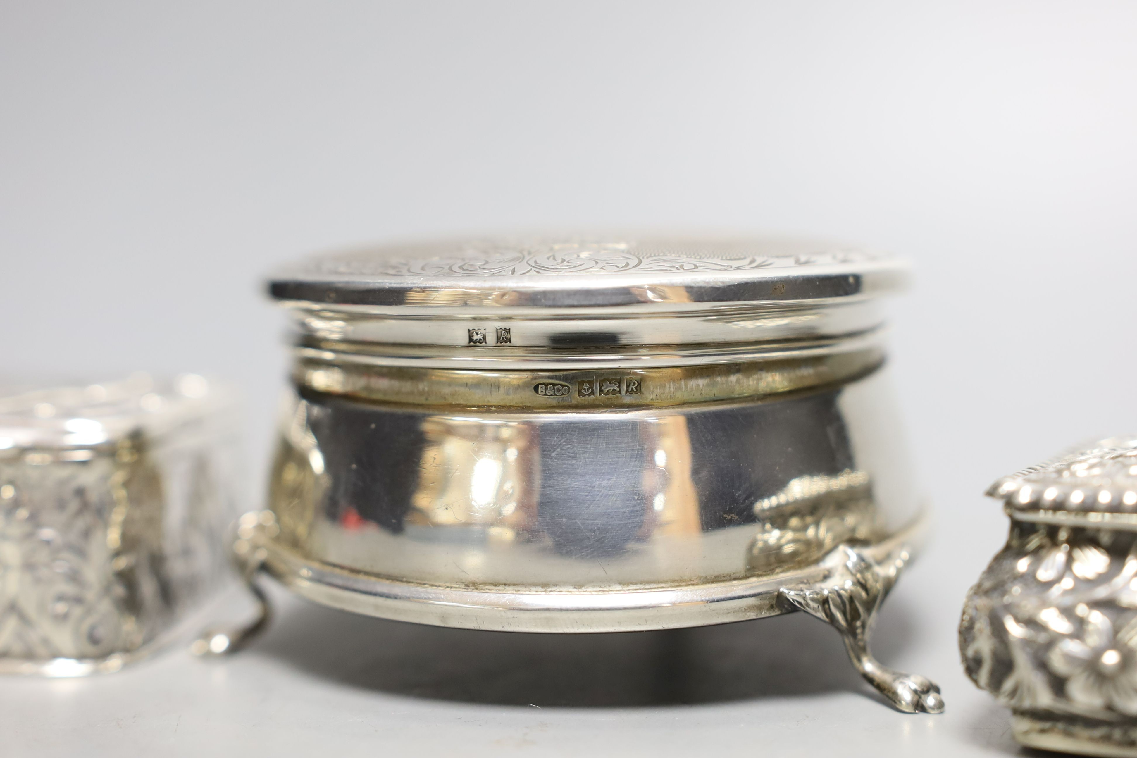 A modern silver mounted trinket box,82mm and two late Victorian embossed silver small boxes.